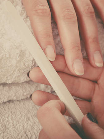Woman hand on towel, beautician file nails. Beauty wellness spa treatment, manicure conceptの写真素材