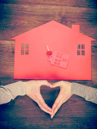 Love romance housing security family concept. Heart and house symbol. Hands forming love shape on home and keys. の写真素材