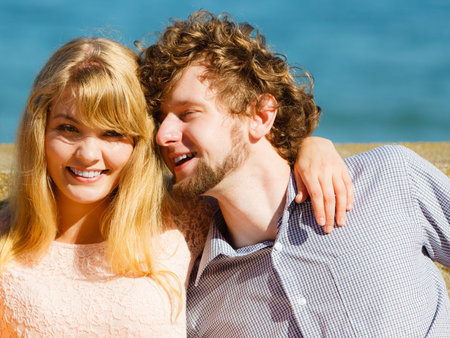 Happy smiling young woman and man outdoor. Pretty attractive people by sea ocean water.
