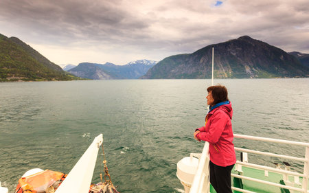 Travel holiday and tourism. Tourist woman on cruise ship boat enjoying fjord Norddalsfjorden view, Norway Europeの写真素材