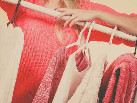 Shopping, outfit ideas concept. Woman hands picking clothes from hangers in clothing shop, wardrobe...