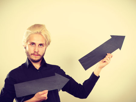 Planning, directions, choices concept. Man holding two black arrows pointing in the same directions....