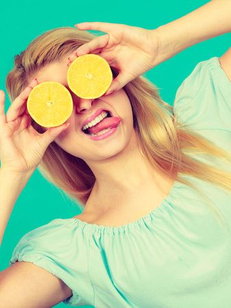 Healthy diet, refreshing food full of vitamins. Woman holding sweet delicious citrus fruit, lemon...