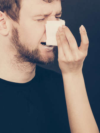 Hygiene and skincare concept. Protection and help in relationship. Woman hand wipe cream face nose of funny man by hygienic tissue. Girlfriend takes care of her boyfriend.の写真素材