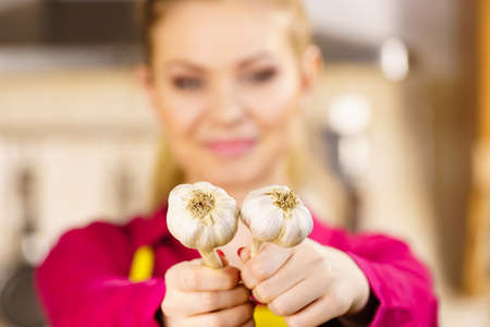 Woman holding healthy herb, two fresh natural garlic. Healthy eating and dieting concept.の写真素材