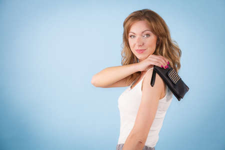 Happy young elegant woman holding purse wallet ready for shopping or partyの写真素材