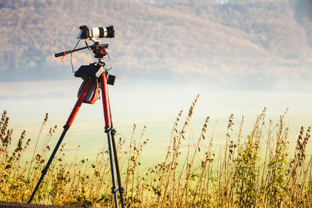 Professional camera on tripod taking picture film video of morning landscape in Slovakiaの写真素材