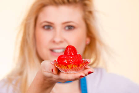Sweets, junk food, sugar temptation on diet concept. Woman holding sweet delicious cupcakeの写真素材