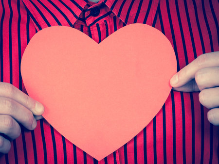 Love hope and help concept. Man holding beautiful red heart in hands. Part body of charity...