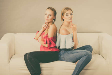 Two young pretty women being mad at each other after argue of fight. Friendship rivaly and envy problems.の写真素材