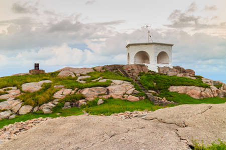 Historic red white lighthouse on the edge of rocky sea coast, South Norway, Lindesnes Fyr beaconの写真素材