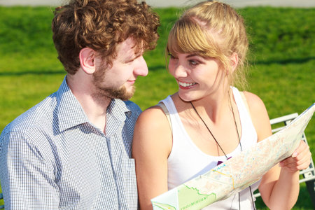 Summer tourism concept. Young tourist couple two friends on vacation in city looking up directions...