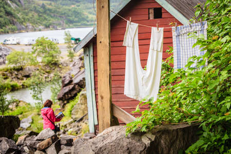Tourist woman visiting the Helleren houses in Jossingfjord along road 44 between Egersund and Flekkefjord, Sokndal municipality, Norway.のeditorial素材