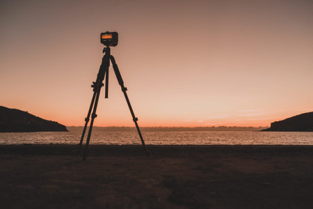 Professional camera taking picture film video of sunset over sea surface, Greece Peloponnese