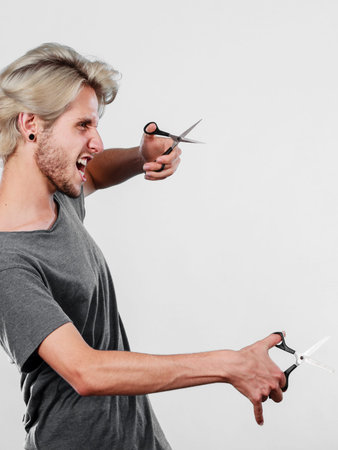 Haircut coiffure haircare concept. Passionate male hairdresser holding scissors showing work tools...