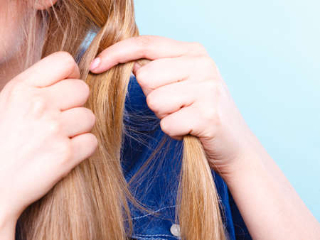 Hairstyle and hairdo. Haircare concept. Blonde woman playing with straight long hair. Hairstylist barber making braid tress coiffure.の写真素材