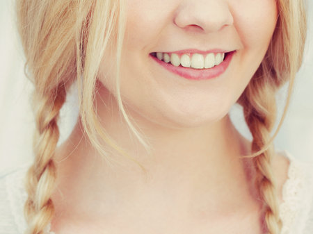 Happy funny woman having long blonde hair in two braided hairstyle. Haircare concept.