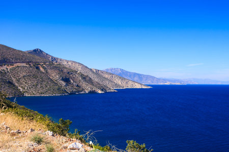View from cliff on beautiful Greek seaside coastline. Sea water, blue ocean.