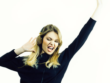 Teenager young grunge woman wearing black and listening to music on headphones with spikesの写真素材