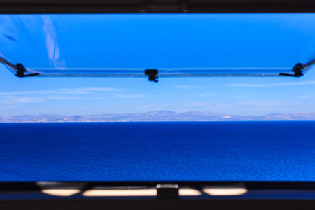 View from camper van window on beautiful calm blue pure sea ocean water.