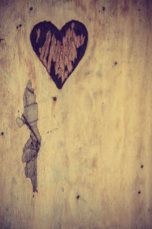 Small heart shape in piece of wood. Romantic detail close up concept.の写真素材