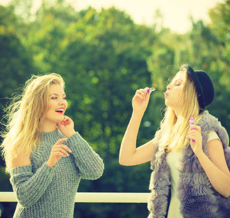 Vacations joy, friendship concept. Women friends having fun blowing soap bubbles outdoor.の写真素材