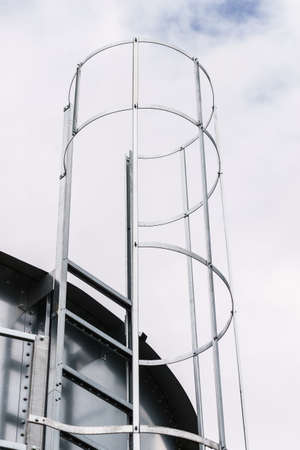 Industrial metal ladder with round protection, railing. Safety rules, agricultural industry objects details.の写真素材