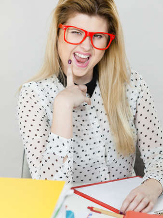 Happy business woman feeling energetic sitting working at desk full off documents in binders.の写真素材