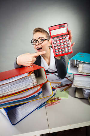 Calculations and results concept. Woman in office calculate company finance. Businesswoman with big red calculator in hand.の写真素材