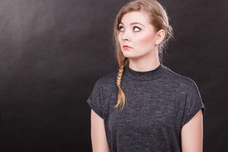 Bad and negative emotions and feelings concept. Blonde unhappy sad woman. Depressed dissatisfied young girl portrait. Facial emotions.の写真素材