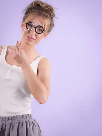 Elegant young woman pretending wearing funny nerd eyeglasses. Education and studying females look concept.の写真素材
