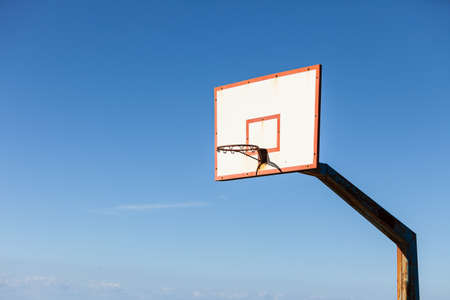 basketball board with basket hoop against blue sky.の写真素材