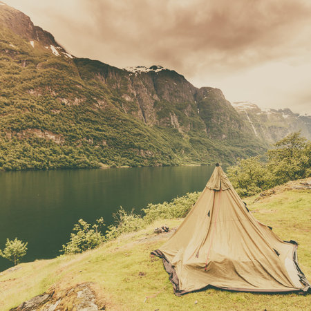 Tourism vacation and travel. Mountains landscape fjord and tent on warer shore, Norway Scandinavia...