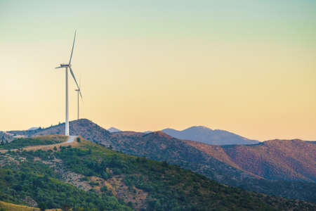 Windmills on Greek hills. Wind farm, source of renewable green energy in Europe. Ecologogy concept.の写真素材