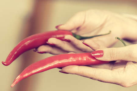 Unrecognizable woman holding red chilli hot pepper paprika. Spicy food, oriental seasonings concept.の写真素材