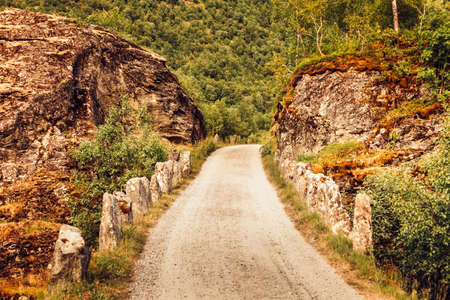 Old road running through norwegian mountains. Travel and tourism.の写真素材