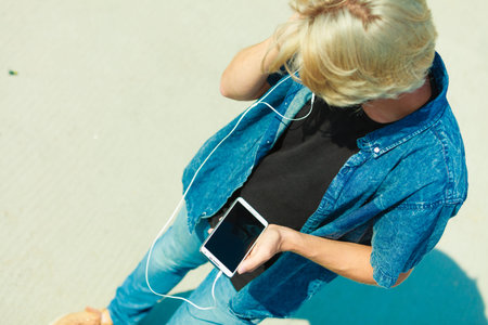 Contacts, technology concept. Young blonde man on vacations using his smartphone to check social...
