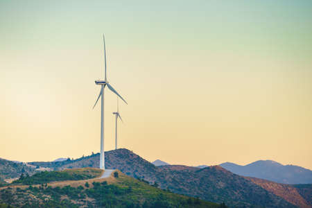 Windmills on Greek hills. Wind farm, source of renewable green energy in Europe. Ecologogy concept.の写真素材