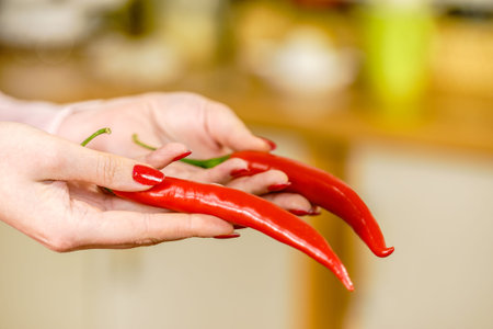 Unrecognizable woman holding red chilli hot pepper paprika. Spicy food, oriental seasonings concept.
