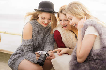 Female photographer showing fashion models results of photo shoot. Behind the scenes of professional modeling and photography industry.の写真素材