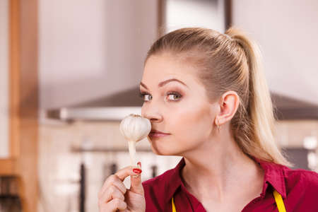 Woman holding healthy herb, two fresh natural garlic smelling it. Healthy eating and dieting concept.の写真素材