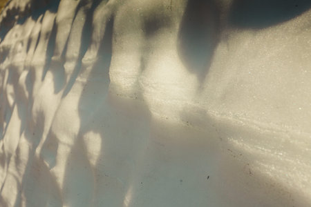 Snowy wall in mountains with sun light as background texture
