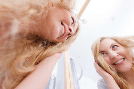 Happy woman having wet blonde hair. Positive clean female after taking a shower feeling clean and relaxed. Unusual crazy bottom angle.の写真素材