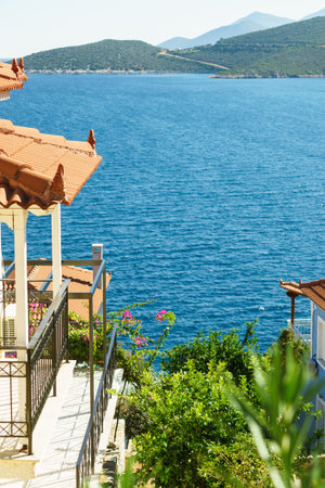 Roofs of Greek houses in suburbs of seaside tourist town. Mediterranean architecture, traveling in...