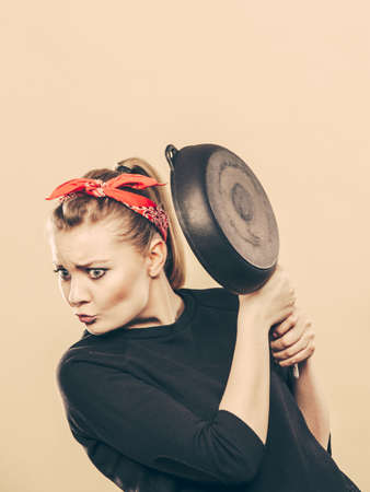 Disagreement in cooking. Kitchen accessories equipment in move. Girl having argument fight. Expression of fear.の写真素材