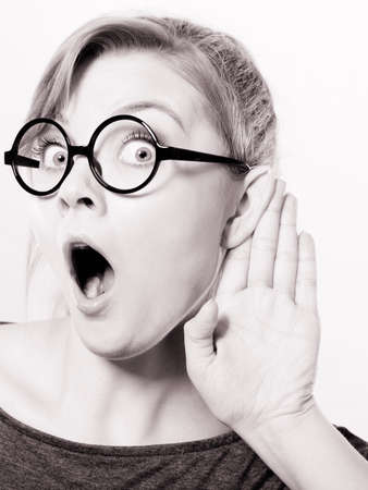 Hearing gesture shock emotion concept. Shocked girl eavesdropping. Young nerdy stunned lady in glasses listening expressing disbelief gasping.の写真素材
