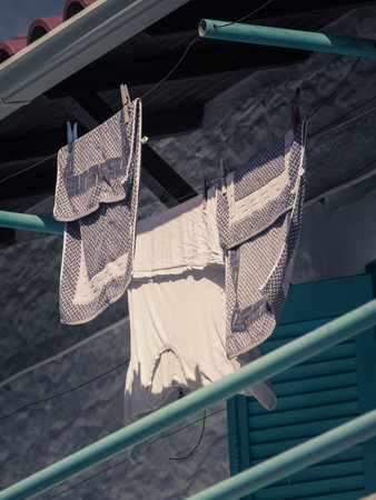 Clothes after laundry drying on a string outdoor. Household duties objects details concept.