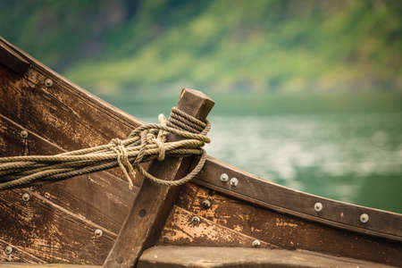 Part of old wooden viking boat outdoor on nature fjord shoreの写真素材