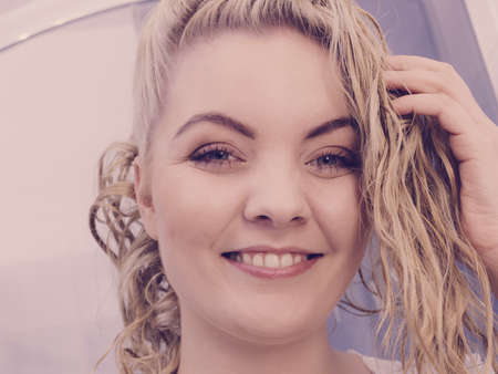 Happy woman having wet blonde hair. Positive clean female after taking a shower feeling clean and relaxed.の写真素材