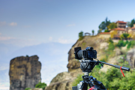 Professional camera on tripod taking picture film video from Meteora monasteries